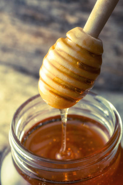 istock Jar of honey with wooden stick 948475346
