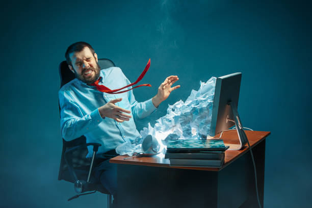 istock Young stressed handsome businessman working at desk in modern office shouting at laptop screen and being angry about spam 948481110
