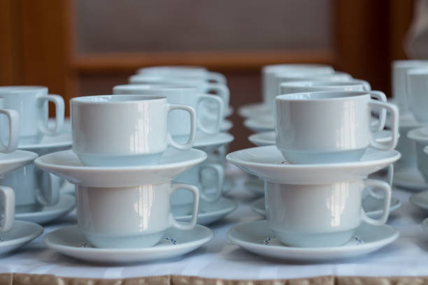 istock White cups for tea piled on table with plates for coffee-break. Catering concept. 948481384