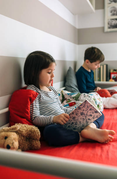 istock Girl and boy reading a book 948482820