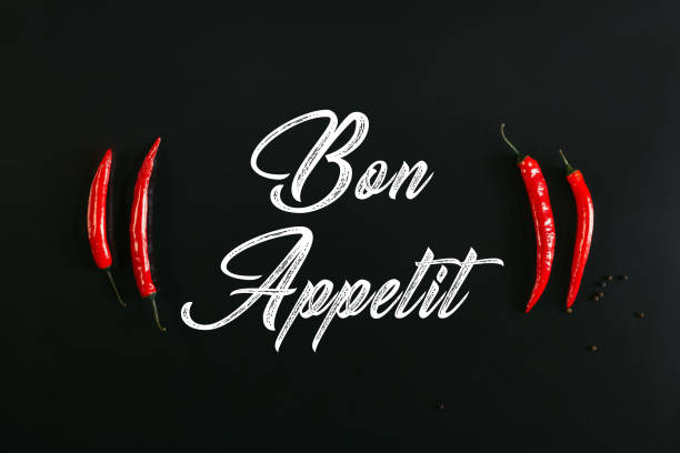 iscrizione bon appetit e peperoncini rossi su nero - bon appetite foto e immagini stock