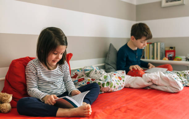 istock Girl and boy reading a book 948485238