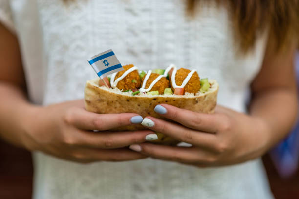 Israel's Independence Day Girl's hands holding pita with falafel and an Israeli flag israeli flag photos stock pictures, royalty-free photos & images