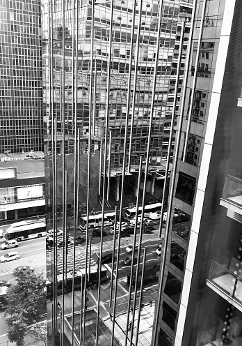 A mirror reflection of traffic in the windows of a skyscraper in São Paulo in Brazil shot in black and white