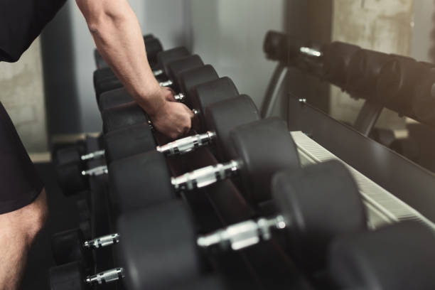 istock Unrecognizable man taking dumbbells at gym 948492278