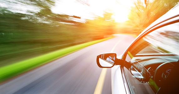 Man driving a car through a forest