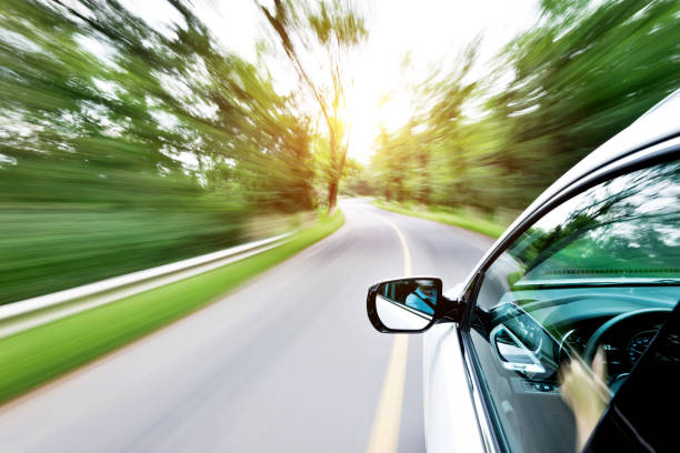 istock Man hand driving a car through a forest 948494794