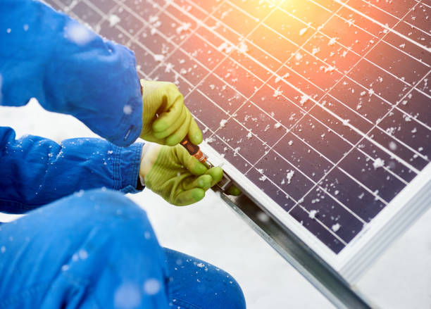 istock Close-up of hands worker installing solar panels in snowy weather 948497414
