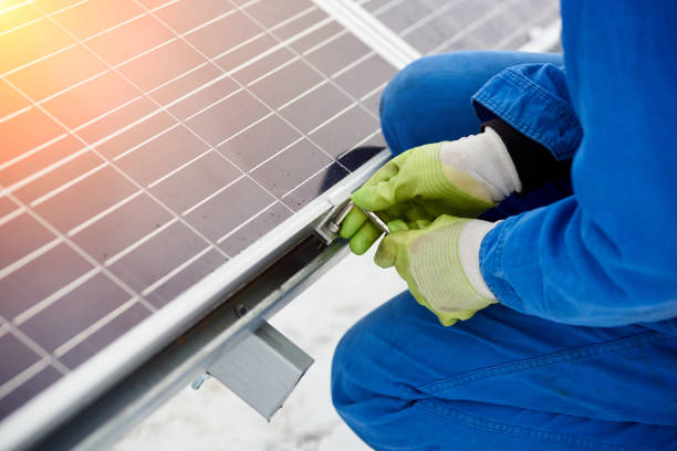 istock Technician in blue suit installing blue solar panels with screw 948498008