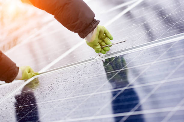 istock Male installs solar batteries using tools in snow-covered weather 948498086