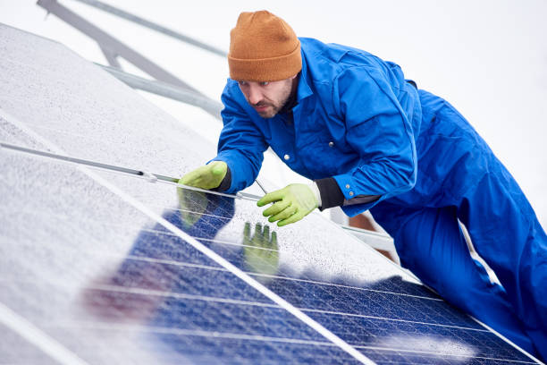 istock Man installs solar batteries using tools on roof in winter 948498130