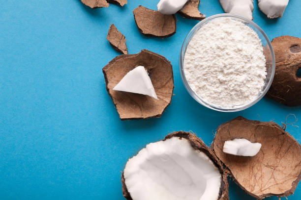 istock Plate with coconut flour and nuts on blue background 948504234