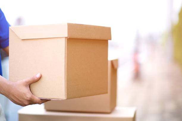 istock parcel delivery man of a package through a service. and close up hand customer accepting a delivery of boxes from delivery man postal 948507074