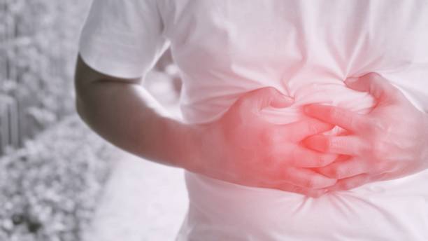 istock Monochrome black and white image unhappy people man stand sick suffering from stomach ache Focus color red on the abdomen area to show pain. concept healthcare and health problem. 948507556