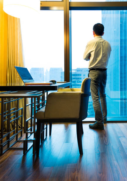 istock Businessman standing and looking out the window 948510736