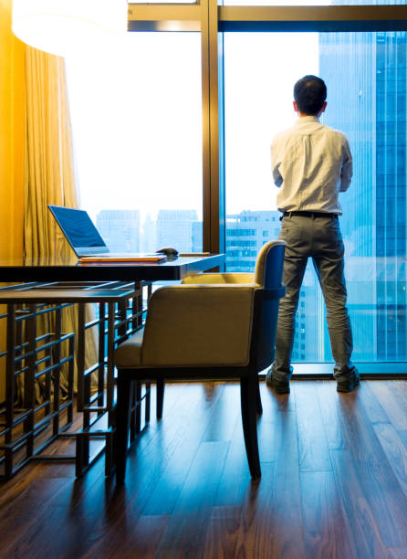 istock Businessman standing and looking out the window 948510880