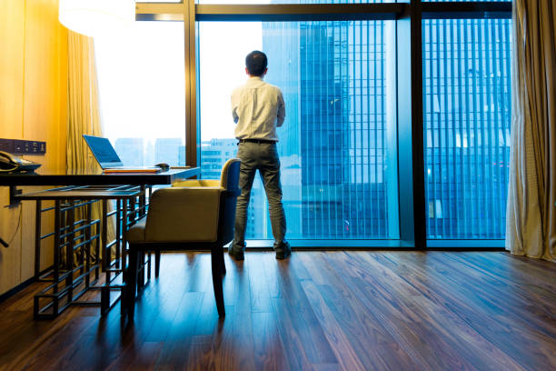 istock Businessman standing and looking out the window 948510884