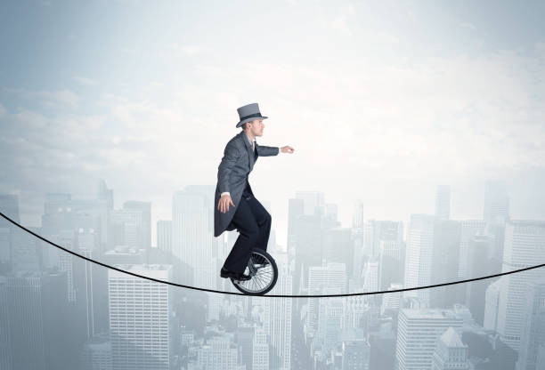 istock Brave guy riding a monocycle on a rope above cityscape 948510952
