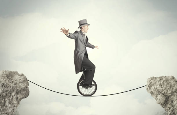 istock Brave business man riding an mono cycle between cliffs 948511010