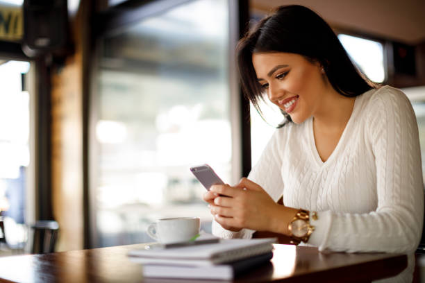 istock Young woman using mobile phone in a coffee shop 948511254