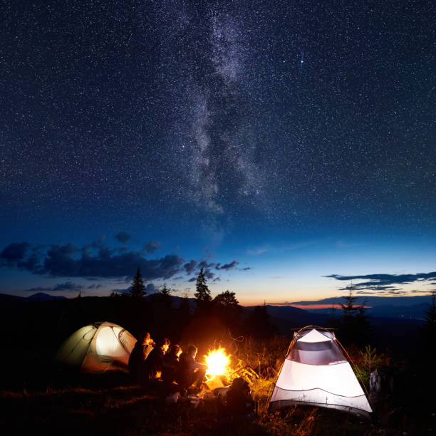 istock Family hikers having a rest at night camping in mountains 948512300