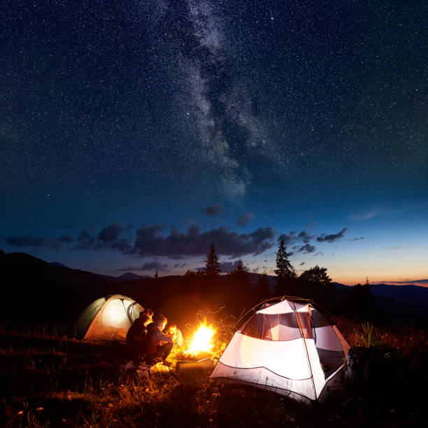istock Family hikers having a rest at night camping in mountains 948512314