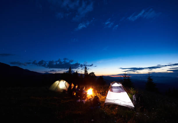 istock Family hikers having a rest at night camping in mountains 948512320