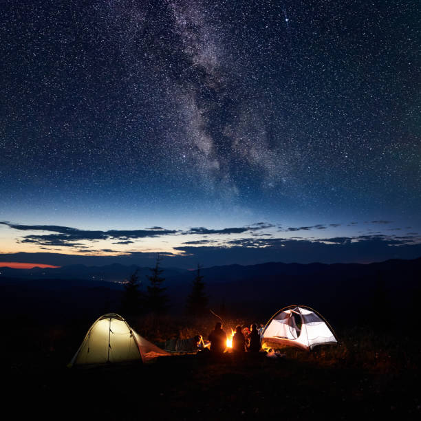 istock Family hikers having a rest at night camping in mountains 948512330