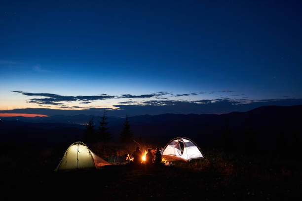 istock Family hikers having a rest at night camping in mountains 948512344