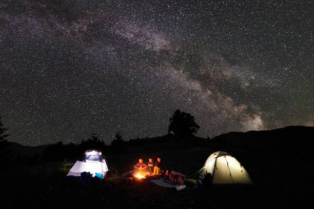 istock Family hikers having a rest at night camping in mountains 948512364