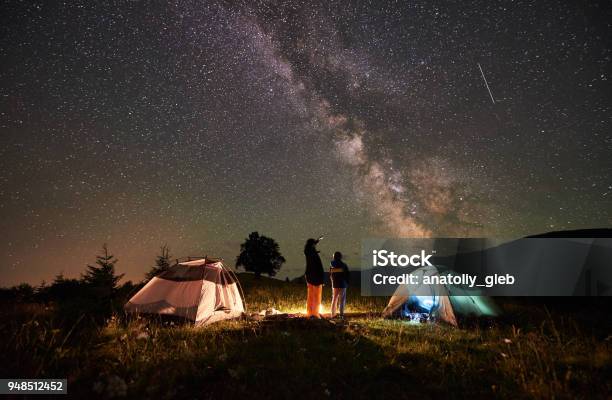 Photo libre de droit de Mère Et Fils Touristes Se Reposer À La Camping En Montagne Au Ciel De Nuit Plein Détoiles Et De La Voie Lactée banque d'images et plus d'images libres de droit de Camping