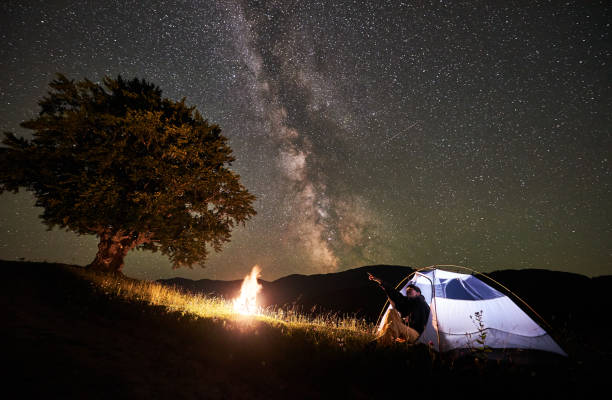 istock Woman tourist resting at night camping under starry sky and Milky way 948512708