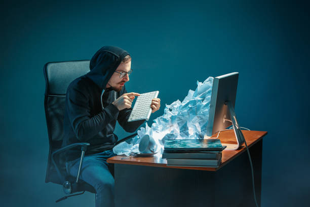 istock Young stressed handsome businessman working at desk in modern office shouting at laptop screen and being angry about spam 948515194
