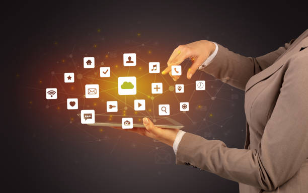istock Hand holding tablet and application icons above 948515852