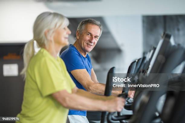 Happy Senior Couple Training On Stair Stepper At Gym Stock Photo - Download Image Now