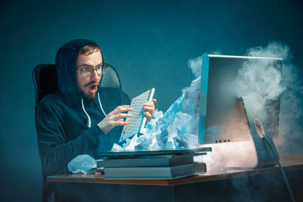 istock Young stressed handsome businessman working at desk in modern office shouting at laptop screen and being angry about spam 948523266