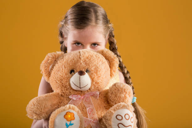 istock Young girl hiding behind big teddy bear 948524504