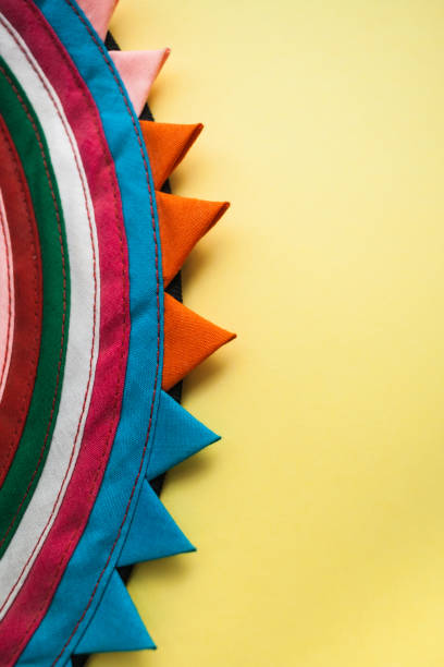 Circular handmade striped cloth on the left and bright pastel yellow background with copy space on the right.