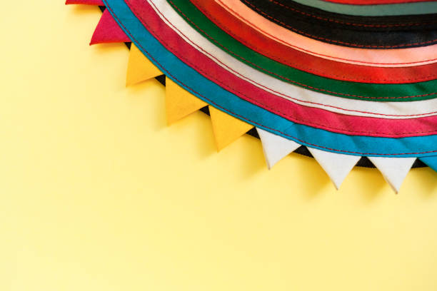 istock Part of circle handmade striped stitched colorful cloth with triangular edges on bright pastel yellow background. 948524986