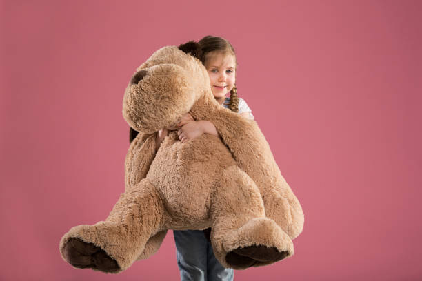 istock Happy young girl holding big teddy bear 948532520