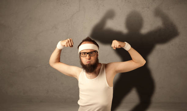 istock Skinny man with musculous shadow 948535634
