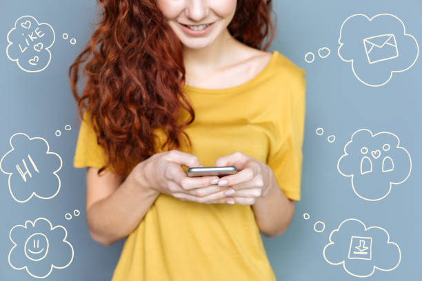istock Cheerful student smiling while sending messages to her friends 948540072