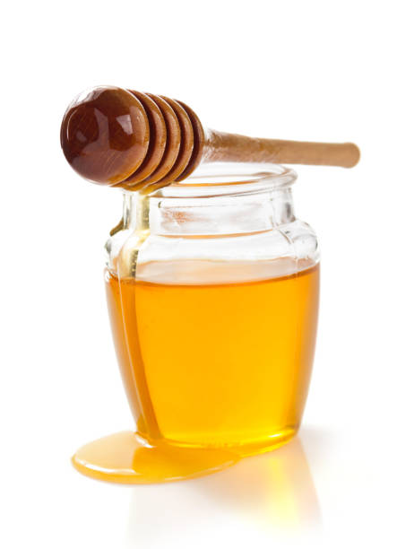 istock glass jar full of honey on white background 948544974