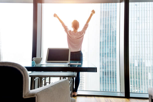 istock Woman standing and looking out the window 948545228