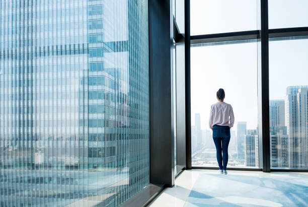 istock Woman standing and looking at cityscape 948545488