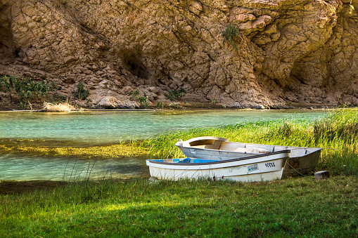 Boats in Mountain river Wadi Shab in Oman with emerald green water