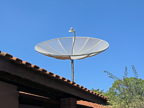 Parabolic antenna fixed to the roof of a house