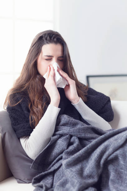 istock Woman sneezing nose with tissue 948559350
