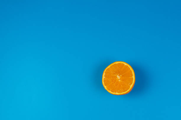 istock Ripe orange cut in half on blue background, top view 948564078