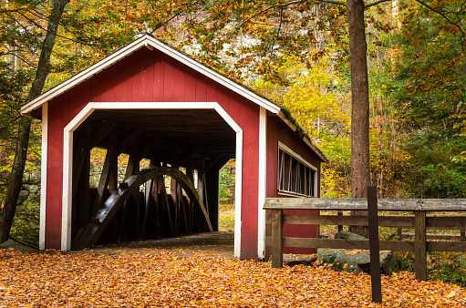 Old Red Covered Bridge in a Forest in Fall. The Path Leading to the Bridge is Completely Covered in Fallen Leaves. Southford Falls State Park, CT